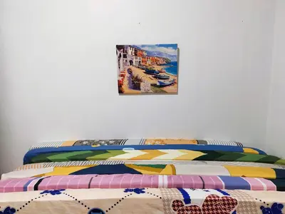 a bedroom with a bed with a painting on the wall at Ipoh Station 18 Homestay in Ipoh