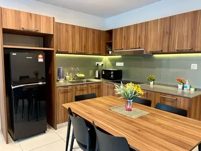 a kitchen with a wooden table with black chairs at Hotspring 2 Room Suite @ Sunway Onsen with Theme Park View 4 to 6 pax in Tambun