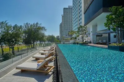a swimming pool with lounge chairs next to a building at Penang Marriott Hotel in George Town