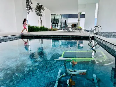 a little girl walking by a swimming pool at New 2BR OR 3BR Cityview Homestay at Urban Suite BY URBAN STAYCATION LDL in Jelutong