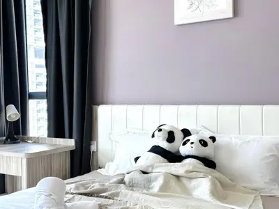 two pandas sitting on a bed with a blanket at New 2BR OR 3BR Cityview Homestay at Urban Suite BY URBAN STAYCATION LDL in Jelutong
