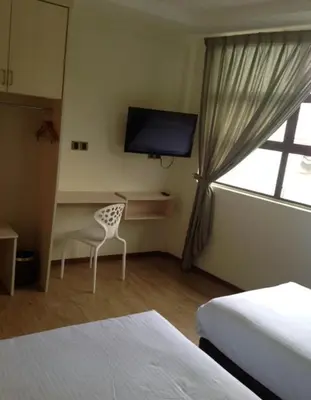 a hotel room with a desk and a window at Merlin Hotel George Town Penang in George Town
