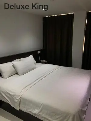 a bed with white sheets and pillows in a bedroom at Hotel Vistana Micassa in Taiping