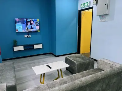 a room with a couch and a table and a tv at Good Night BD Motel -PEKAN BAGAN DATUK-SELF CHECK IN in Bagan Datuk