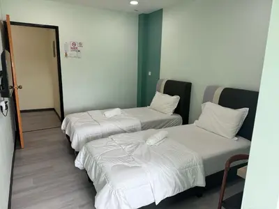 a room with three beds in it with a doorway at Good Night BD Motel -PEKAN BAGAN DATUK-SELF CHECK IN in Bagan Datuk