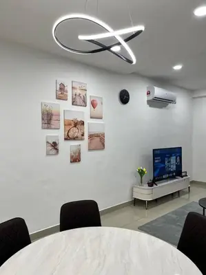 a room with a table and a tv and a wall at Cloud Nine Homestay in Taiping