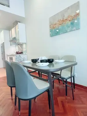 a dining room table with chairs and a painting at Strait Quay Marina Cozy Suite with Bathtub by Uptrend Home Management in Tanjong Tokong