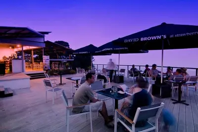 a group of people sitting at tables on a deck at Cheerful 6BR Town House @ Geortown for 5-14pax by Cohans in George Town
