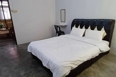 a bedroom with a large bed with white sheets and pillows at Cozy Nature Homestay - Free Wifi Disney Hotstar ADS in Nibung Tebal