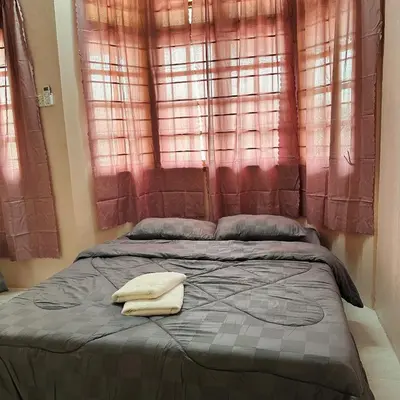 a bed with two towels sitting on top of it at CYC homestay 48 Bercham in Kampong Batu Lapan