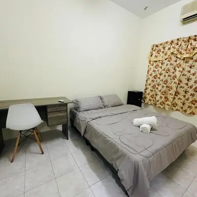 a bedroom with a bed with a desk and a chair at CYC homestay 48 Bercham in Kampong Batu Lapan