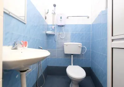 a blue tiled bathroom with a toilet and a sink at Hotel Tudor Home Inn Cameron Highlands in Brinchang