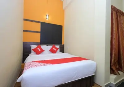 a bedroom with a large white bed with red pillows at Hotel Tudor Home Inn Cameron Highlands in Brinchang