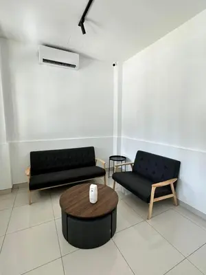 a living room with two black couches and a table at Lodge 43 House in George Town