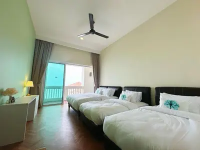 a hotel room with three beds and a window at Straits Quay Highest & Wonderful Seaview Suite in Tanjong Tokong