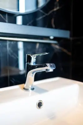 a bathroom sink with a faucet on top of it at Urban Suites with Spectacular High Floor View #3BR #03 in Jelutong