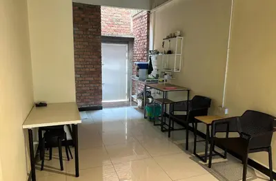 a room with some chairs and tables and a door at Nibong Tebal Studio Home Stay in Nibung Tebal