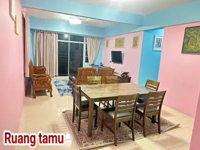 a dining room with a wooden table and chairs at Zurie Muslim Homestay in Brinchang