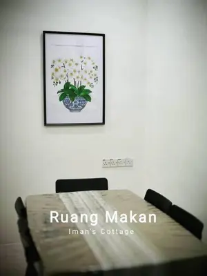 a bed in a room with a picture on the wall at Iman Cottage Homestay Hospital Kulim Hitech in Kulim