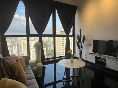 a living room with a couch and a tv and a table at Urban Suites R l 6pax 2R2B l SeaView &CityView l Georgetown in Jelutong
