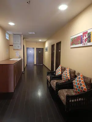 a lobby with couches and a kitchen in a hospital at Beautiful Marigold Hotel in Tanah Rata