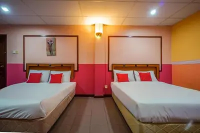 two beds in a room with colorful walls at DJ Seafront Hotel in Lumut