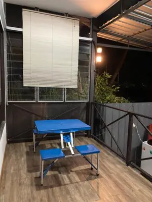 a blue table on a balcony with a window at Rods Homestay - Kg Agong Penaga in Kepala Batas