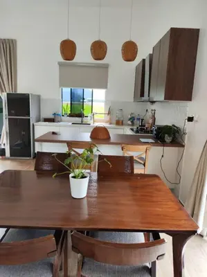 a kitchen with a wooden table with chairs and a dining room at Mai Paddy Cottage, Balik Pulau in Balik Pulau