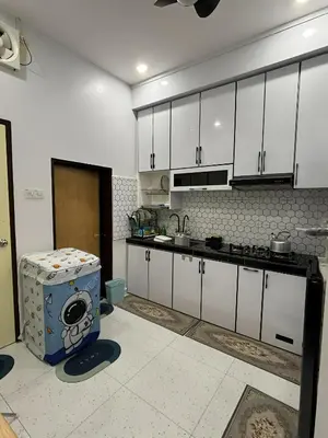 a kitchen with white cabinets and a washing machine in it at Aufa House in Padang Rengas