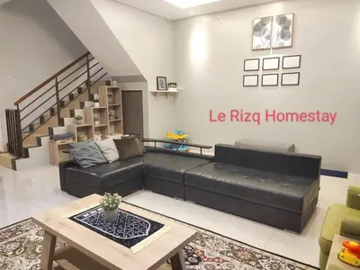 a living room with a black couch and a table at Homestay Gerik Le rizq Homestay~ Heart of Gerik ~ Cozy in Gerik