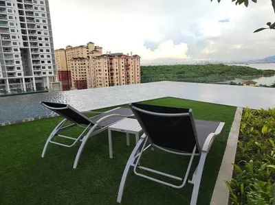 two chairs and a table on the roof of a building at Seaview Infinity Pool , 40th , 9pax, 3Rooms 2Carpark in Jelutong