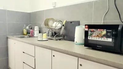 a kitchen counter with a microwave and a sink at Ipoh Cove Hillview Suite 7-8 pax Tambun Lost World by City Home Empire in Ipoh