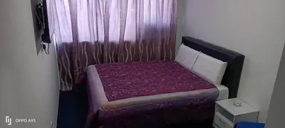 a small bedroom with a bed with a purple blanket at Hotel Blue Orchid in Bayan Lepas