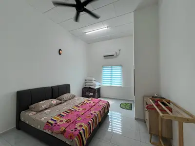 a bedroom with a bed and a ceiling fan at Agro Village Stay in Tapah