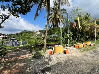 a group of orange and yellow benches in front of a palm tree at Agro Village Stay in Tapah