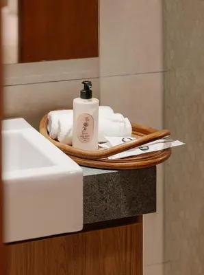 a tray with a bottle of soap and towels on a sink at Mint Villa with Jacuzzi Pool in George Town