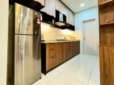 a kitchen with a stainless steel refrigerator and wooden cabinets at Decozy7.0 Ipoh Town Condo(12pax) in Ipoh