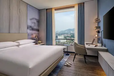 a hotel room with a bed and a desk and a window at Marriott Executive Apartments Penang in George Town