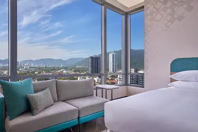 a bedroom with a bed and a couch and windows at Marriott Executive Apartments Penang in George Town