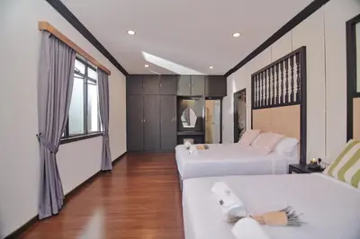 a hotel room with two beds and a couch at Rose Cottage by De'La Ferns in Tanah Rata