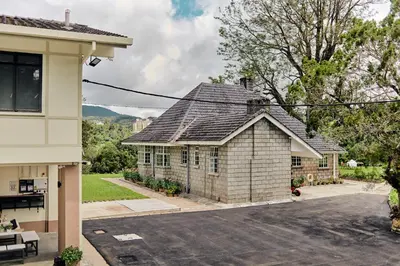 a house with a gray roof on a street at Rose Cottage by De'La Ferns in Tanah Rata