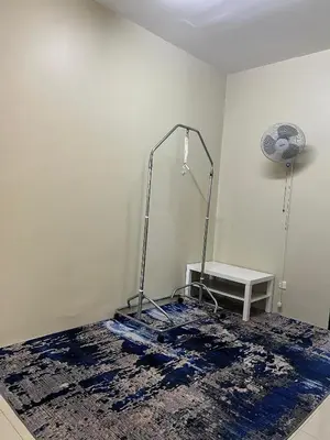 a room with a blue rug and a table at Teratak Amaris Homestay MELAYU ONLY in Sungai Petani