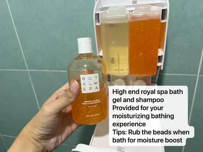 a person holding a bottle of soap in a bathroom stall at Pusing Kampung Affordable Homestay Astro in Pusing