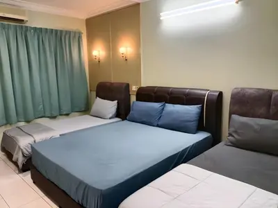 two beds sitting next to each other in a room at Cozy Modern Classic Home in Ipoh in Ipoh