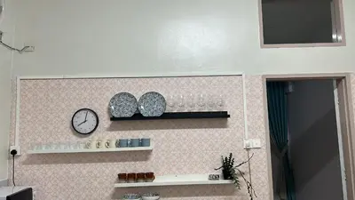 a wall with a clock and a shelf with glasses at The Hidden 7 in Taiping