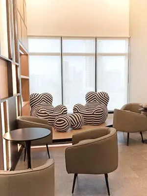 a room with chairs and a table and a large window at Urban Suites 3 Rooms, Cat Theme & Romantic in Jelutong