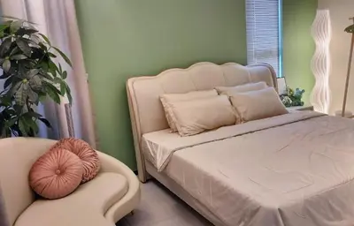 a bedroom with a white bed and a chair at Romantic Sea View Room @ Urban Suites, Jelutong in Jelutong