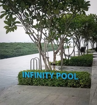 an infinity pool sign in front of a tree at Romantic Sea View Room @ Urban Suites, Jelutong in Jelutong
