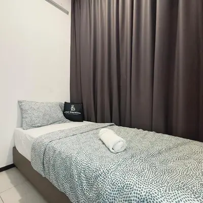 a bedroom with a bed with a black and white comforter at 2BR OR 3BR Wonderful Homestay at Urban Suite BY LJ PULSE in Jelutong