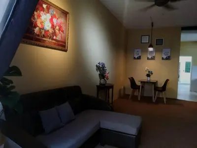 a living room with a couch and a table with chairs at Barakah Sufi Home Stay Apartment Cameron in Tanah Rata